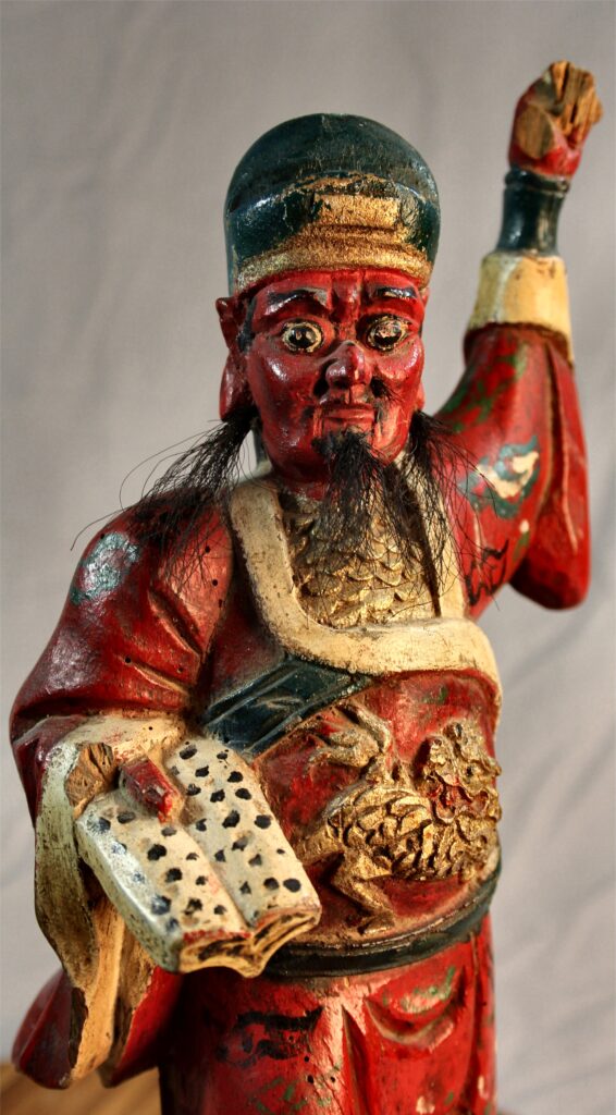 A wooden statue of a hell official holding the ledger of sins from my collection.